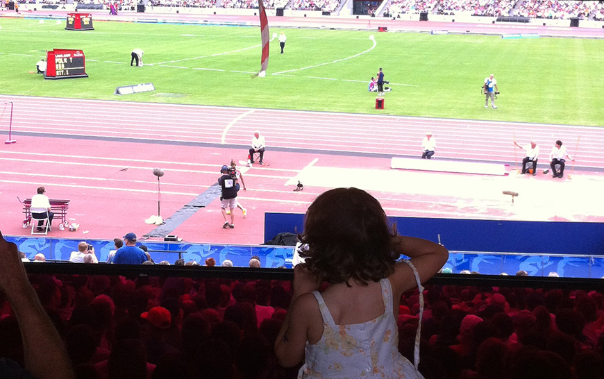 A young girl watches athletes compete at the London Stadium