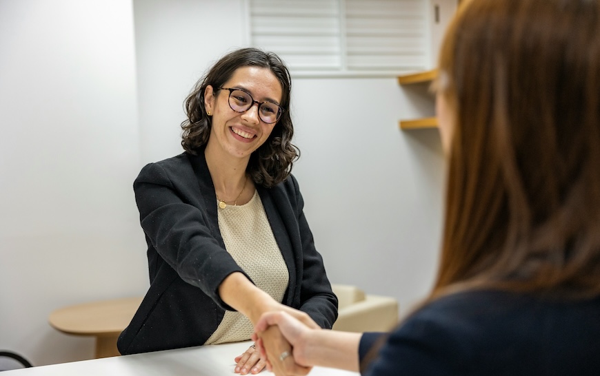 job-offer Two women shake hands across a desk
