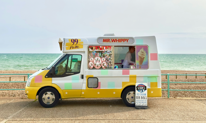 An ice cream van parked on a seaside promenade on a sunny day